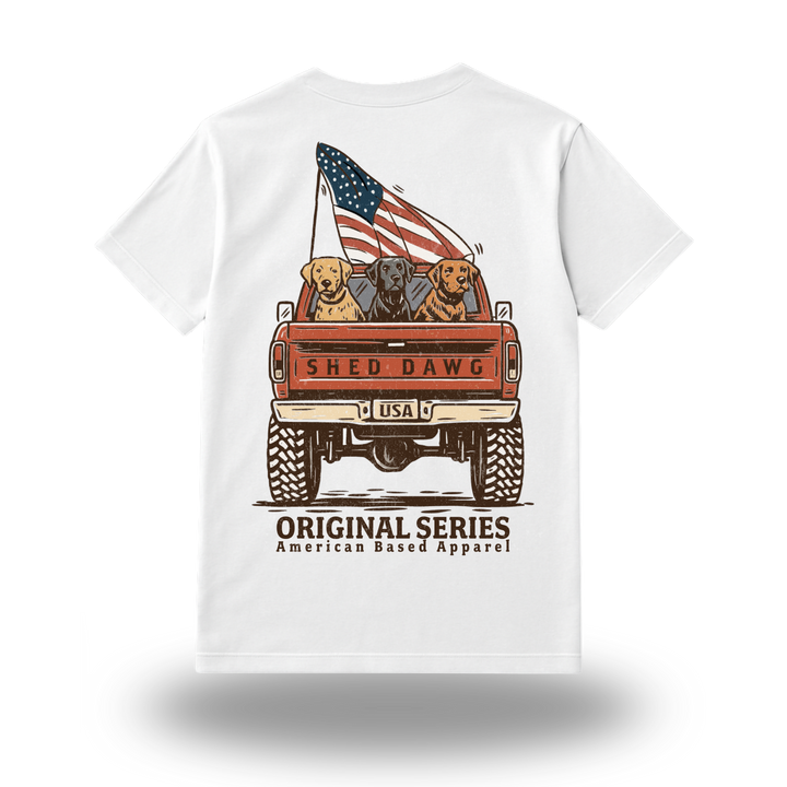 Back view of Shed Dawg Original Series Tee with three retrievers in truck bed and American flag graphic